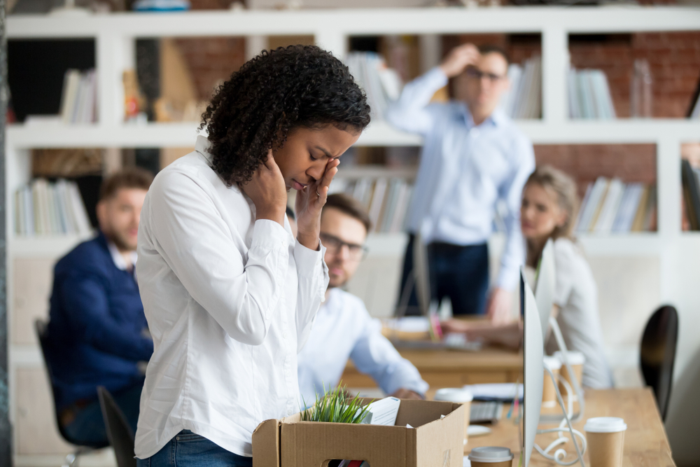 Young employee packing belongings in box at workplace got fired from job.